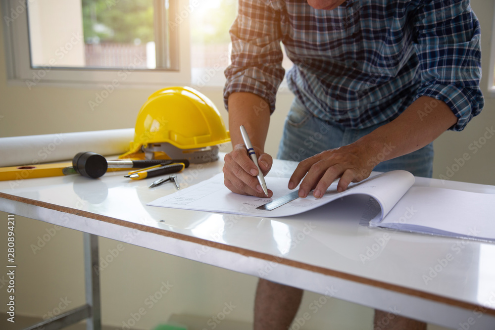 architect man handwriting with blueprint to build houses. After agreeing the employment price the cost of construction and repair real estate architect man handwriting with blueprint to build houses. After agreeing the employment price the cost of construction and repair real estate