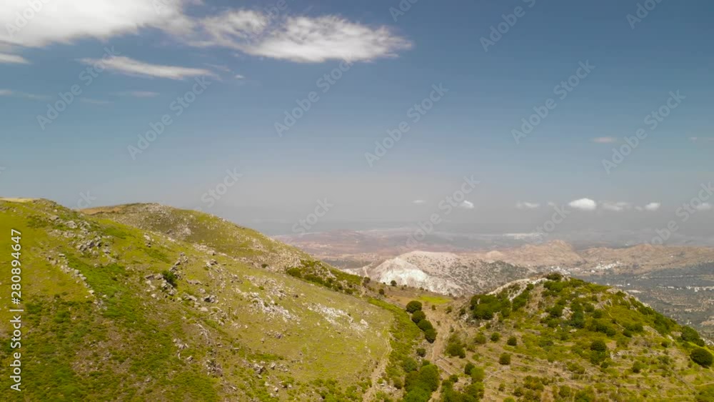 Greek Island Inland Lanscape Aerial. Flying Over Green Hill With Valley in Background Under Summer Sun Greek Island Inland Lanscape Aerial. Flying Over Green Hill With Valley in Background Under Summer Sun