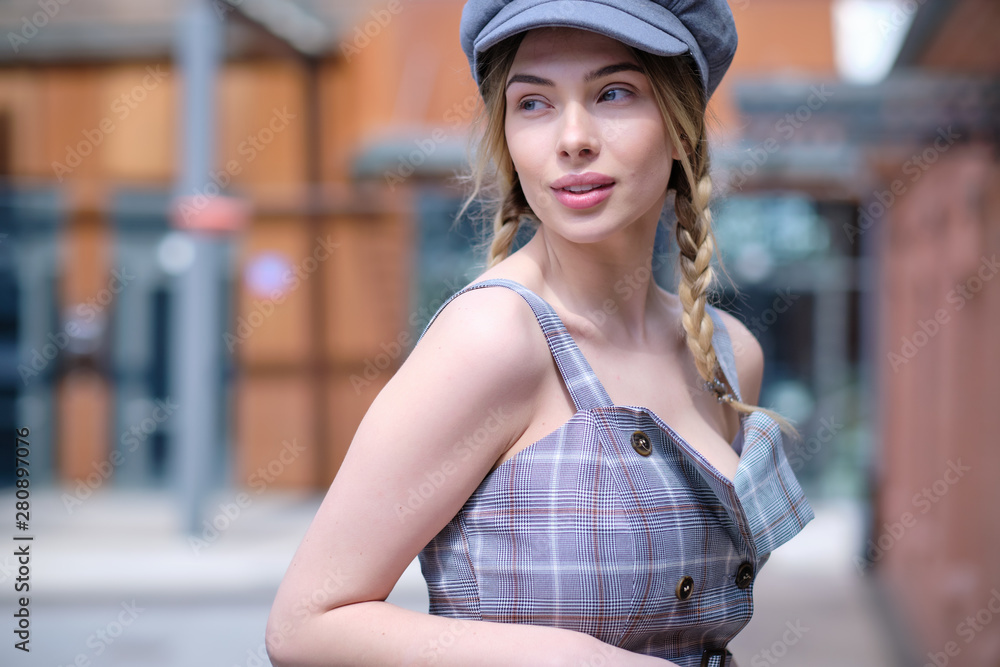 Charming young woman with long blonde hair walks along the street in an old town Charming young woman with long blonde hair walks along the street in an old town