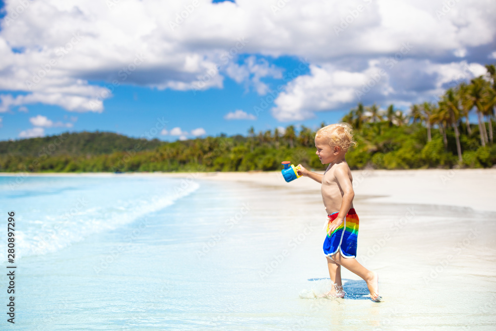 Naklejka premium Kids play on tropical beach. Sand and water toy.