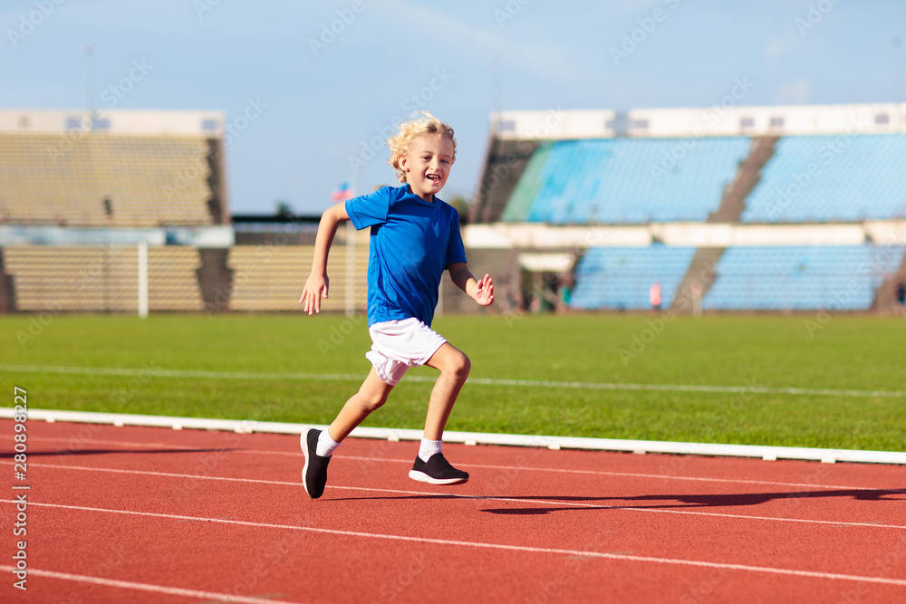 Child running in stadium. Kids run. Healthy sport.