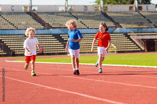 Child running in stadium. Kids run. Healthy sport.