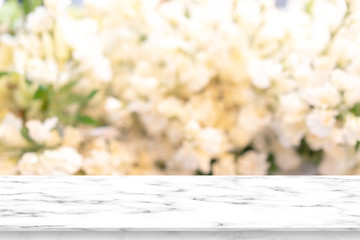 abstract blur beautiful flowers and floral background in beauty shop with white marble counter tabletop texture perspective counter for promote and show and advertise product on display	