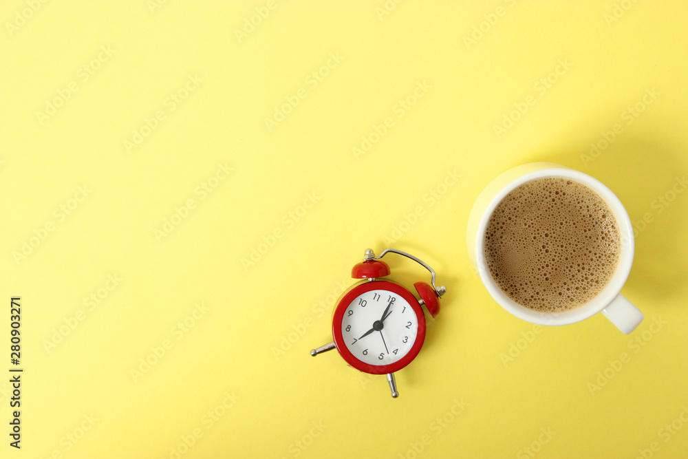 alarm clock and coffee on a colored background top view. alarm clock and coffee on a colored background top view.