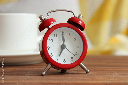 Alarm clock and cup of coffee in the room interior
