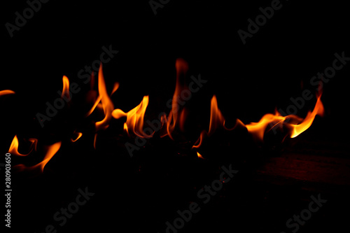 Flame on a wooden pile on a black background.