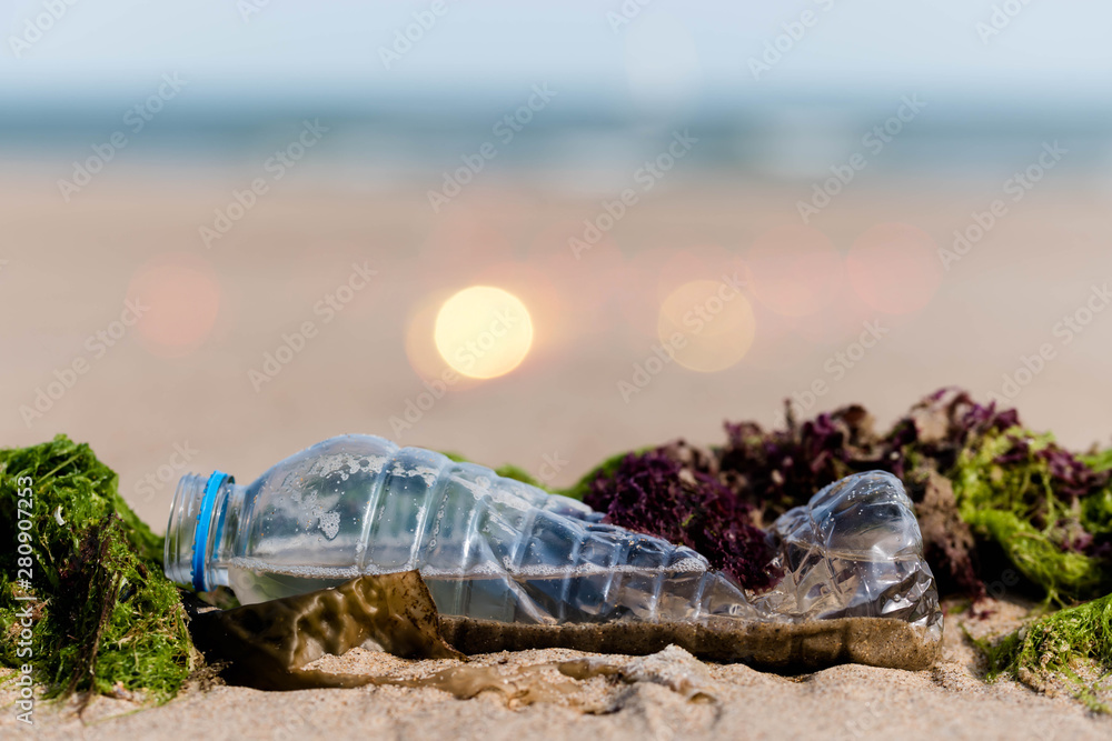 plastic bottle on sand and polluting the beach