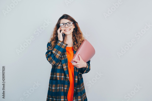 Happy successful European businesswoman talking on smartphone, standing over gray background. Copy space. Business talk concept.
