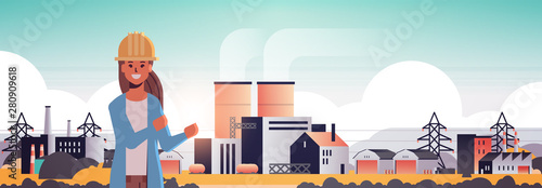 female engineer in helmet working on manufacturing factory industrial zone plant with pipes and chimney power station production technology concept horizontal portrait flat