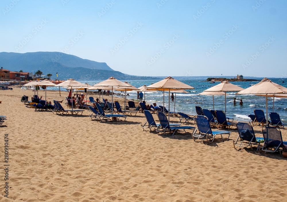 People are resting on a sunny day at the beach in Malia, Crete, Greece