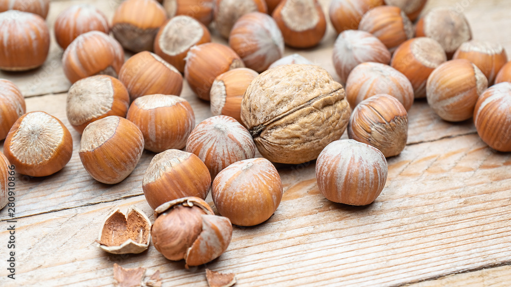 Hazelnut heap on wooden table, selective focus