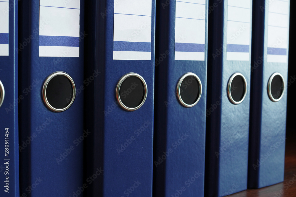 closeup of blue file binders in a row on a shelf closeup of blue file binders in a row on a shelf