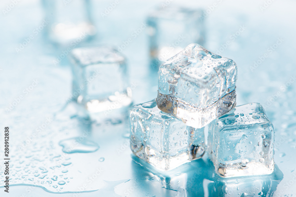 Frozen ice cube on blue background with empty space for text Frozen ice cube on blue background with empty space for text