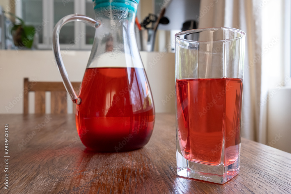 glass and jug of herbal fruit tea glass and jug of herbal fruit tea