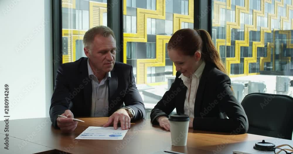 Business people discuss documents Business people discuss documents