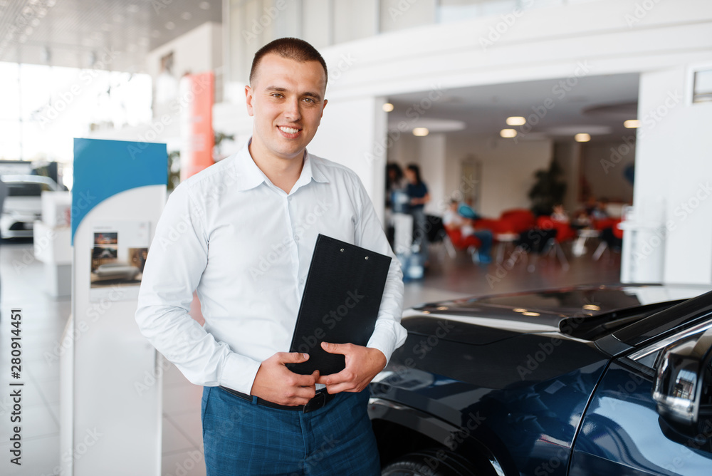 Fototapeta premium Salesman shows new car in showroom