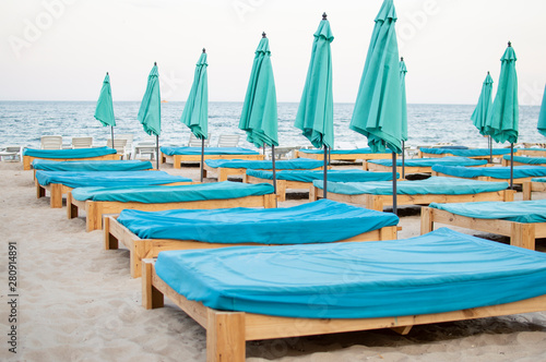 many empty beach beds near the sea, a beach without people, an abandoned resting place