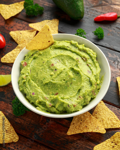 Bowl of fresh Guacamole with nachos chips and herbs. Healthy Vegan, Vegetables food.