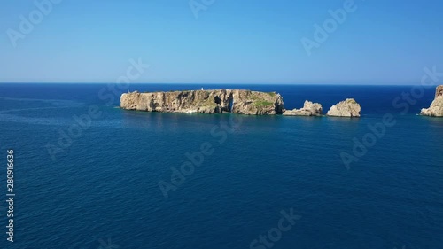 Aerial drone video of small islet (Pilos) with iconic rocky arch and monument of French naval forces in Battle of Navarino called Pylos next to Sfaktiria island, Pylos, Peloponnese, Messinia, Greece photo