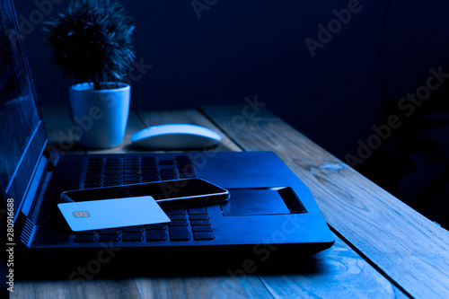 The concept of credit card theft. Hackers with credit cards on laptops use these data for unauthorized shopping. Unauthorized payments from credit card owners. In the hacker's secret office