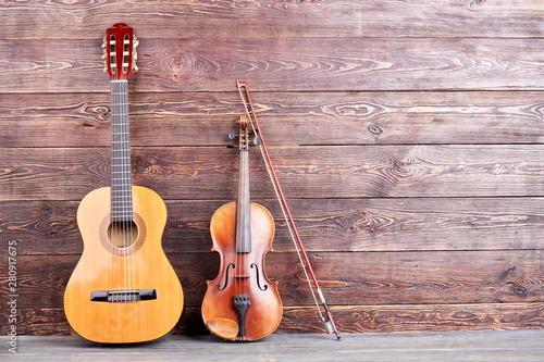 Vintage musical instruments and copy space. Retro guitar and violin on wooden background. Classical musical instruments. © DenisProduction.com