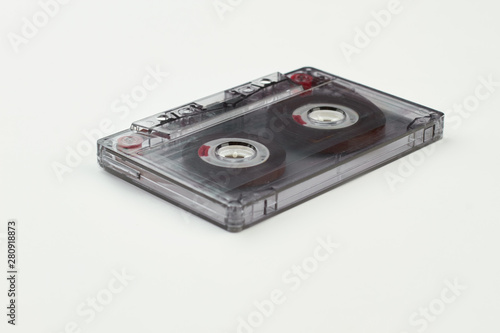 Compact cassette with clipping path. Transparent audio tape over white background. Old-fashioned musical object.