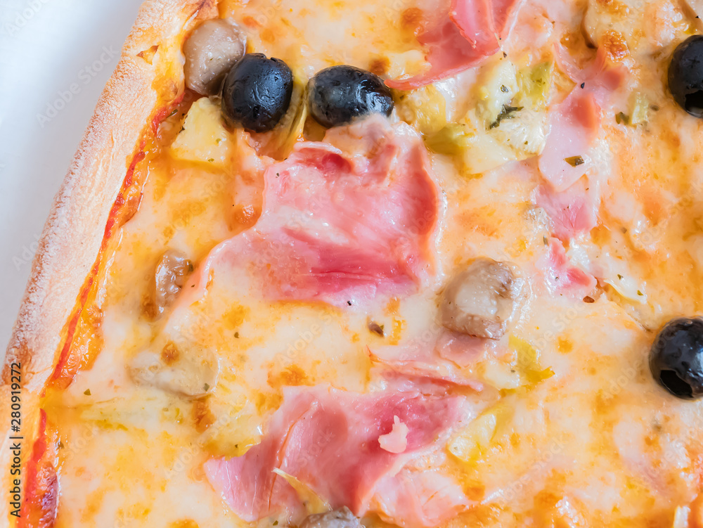 Close up of an Italian pizza with olives, ham, mushrooms and cheese. Close up of an Italian pizza with olives, ham, mushrooms and cheese.