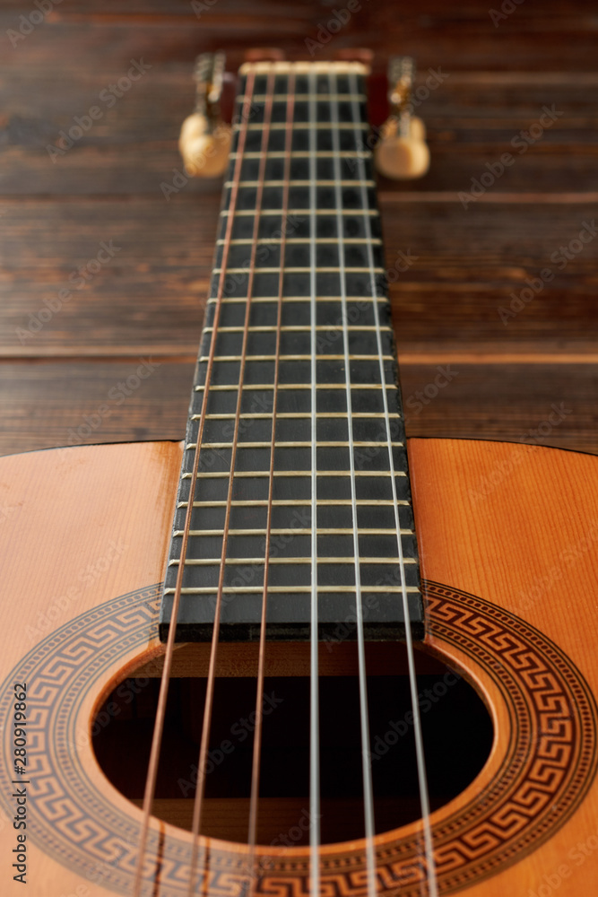 Obraz premium Six-strings guitar, vertical image. Acoustic guitar close up. Classical music instrument.