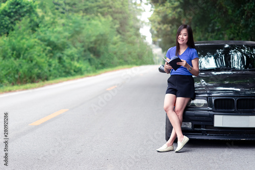 Smile woman traveler standing and reading a book with her car © arrowsmith2