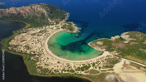 Aerial drone video of semicircular sandy beach and lagoon of Voidokilia, one of the most iconic beaches in Mediterranean sea, with crystal clear turquoise sea, Messinia, Greece photo