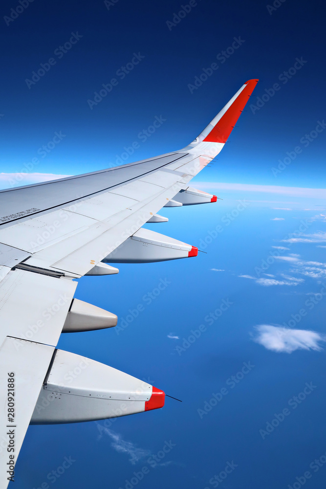 Fototapeta premium Airplane wing over the sky background, view from window