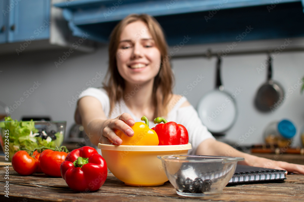 young girl prepares a vegetarian salad in the kitchen, she takes out a yellow pepper from the plate, the process of preparing healthy food young girl prepares a vegetarian salad in the kitchen, she takes out a yellow pepper from the plate, the process of preparing healthy food