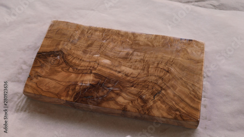 woodworker applying oil finish to olive wood board from above photo