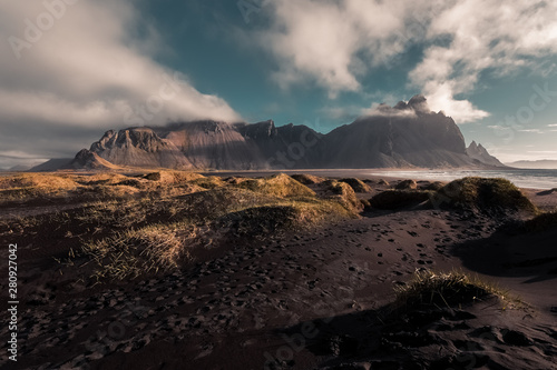 Famous Vestrahorn mountain in Stokksnes, Iceland. Sunrise on beach full of tufts of grass.