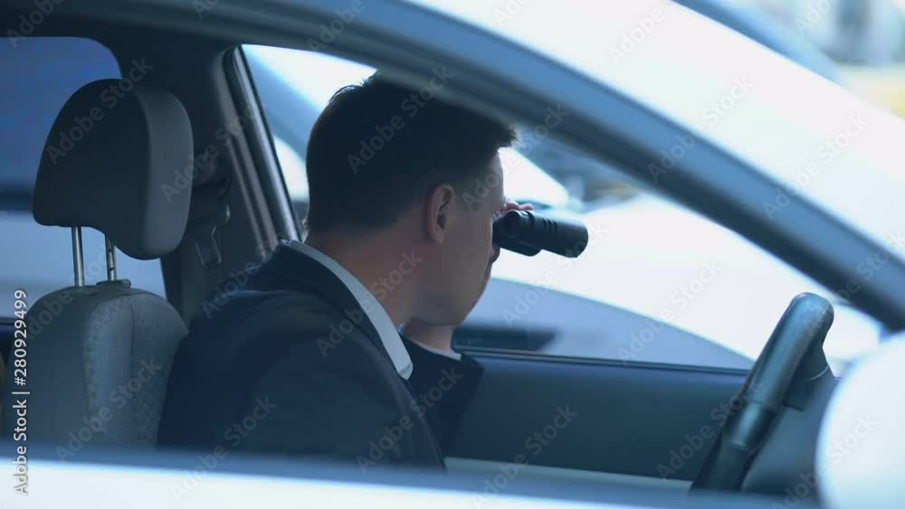 Secret spy in car looking through binoculars, confidential information search Secret spy in car looking through binoculars, confidential information search