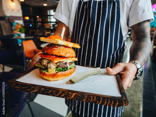 Big burger with beef cutlet, white bun and pepperoni pizza