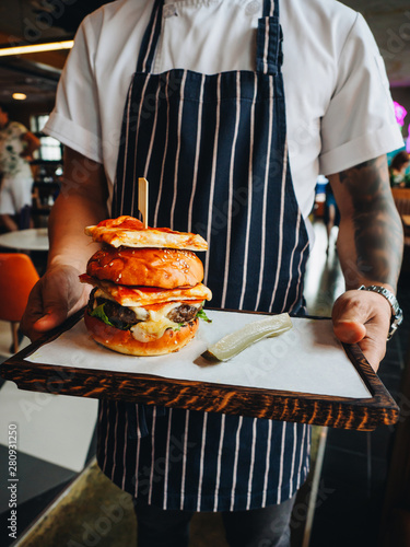 Big burger with beef cutlet, white bun and pepperoni pizza
