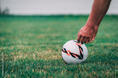 soccer ball in hand on green grass
