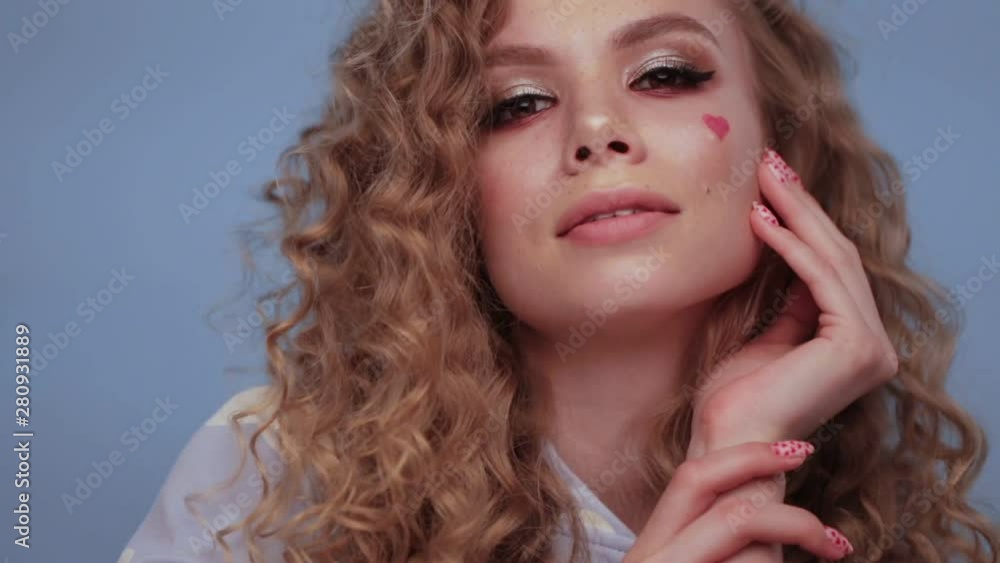 Pretty girl with curls hairstyle, classic makeup, freckles, nude lips