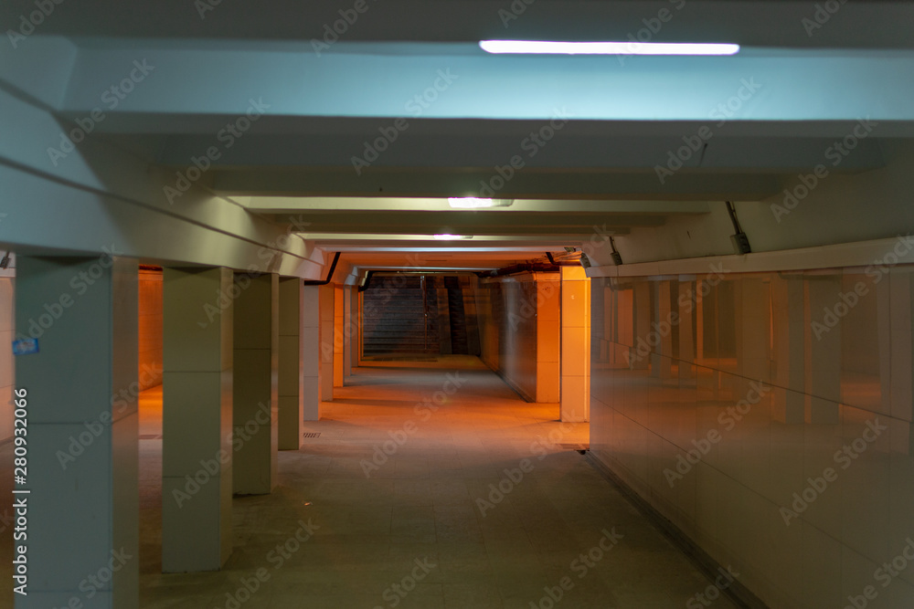 Underpass under the street in the city. Empty underpass with poor lighting.