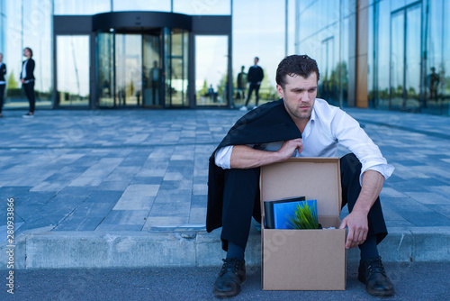 Fired business man sitting on street photo