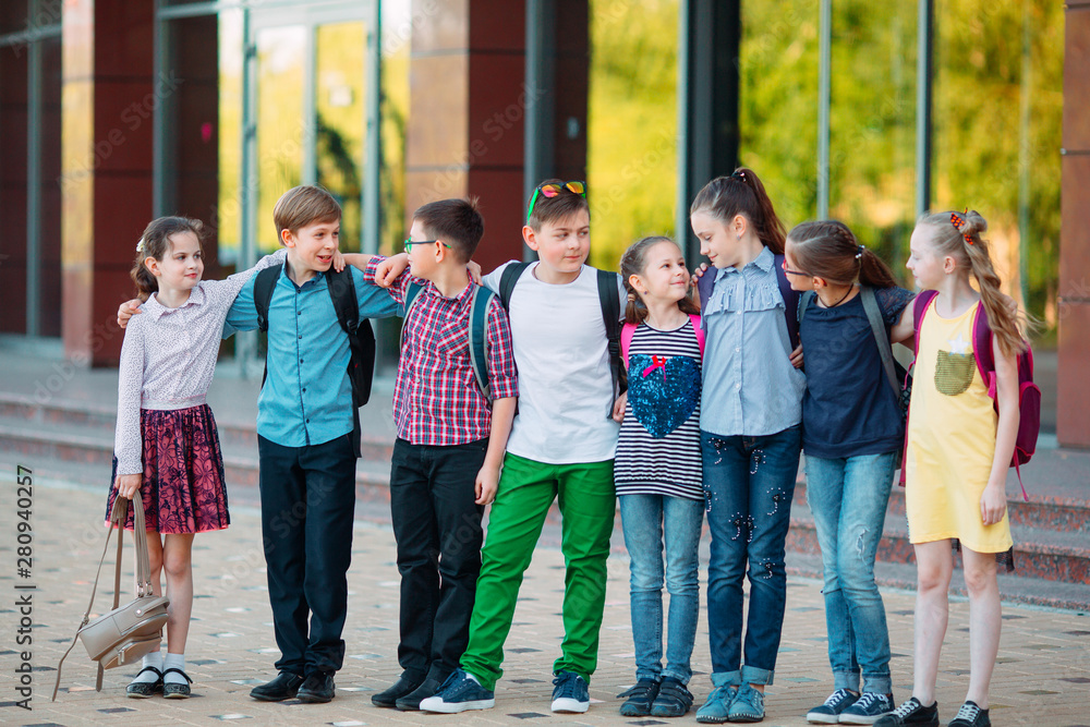 Children's friendship. Schoolmate students stand in an embrace on the schoolyard. Children's friendship. Schoolmate students stand in an embrace on the schoolyard.