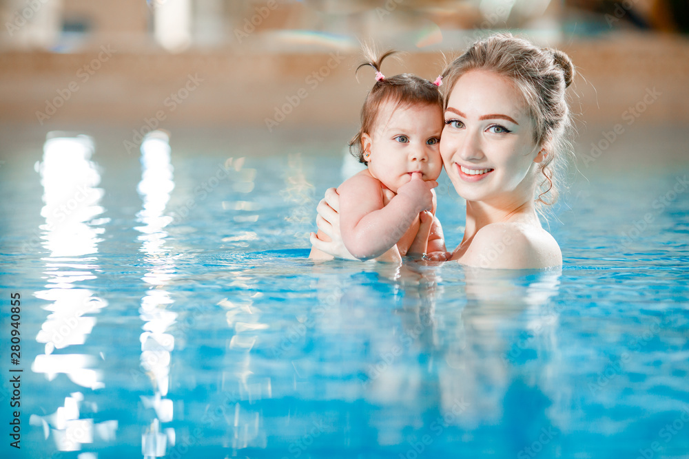 Mom and baby swim in the pool.