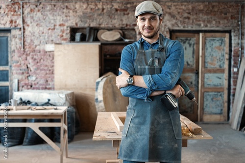 Successful handsome businessman with stylish cap work in carpentry