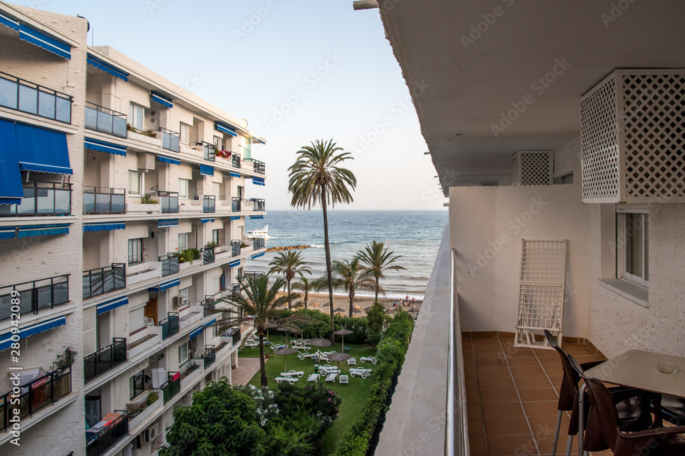 High rise European style beach apartments with patios and palm trees along side the Mediterranean Sea in Marbella, Spain