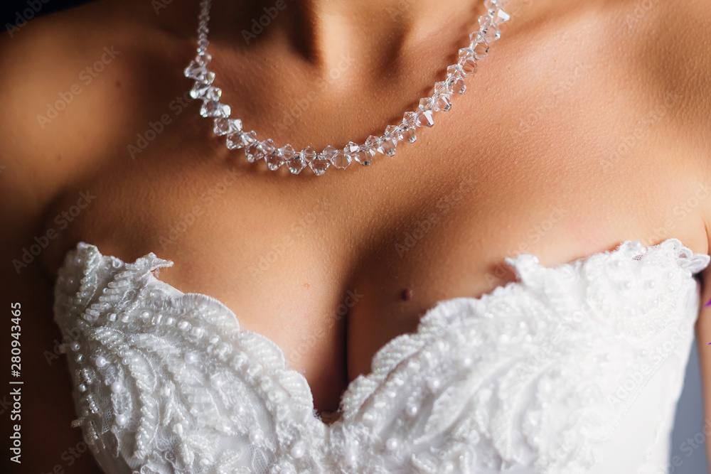 Close-up of the neckline of the bride with a beautiful necklace.