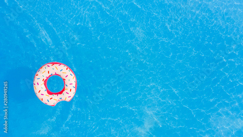 Aerial view of big pink donut in the swimming pool.