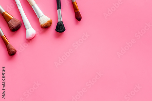 Fototapeta Naklejka Na Ścianę i Meble -  Brushes for make up on pink visagiste work desk background top view copyspace