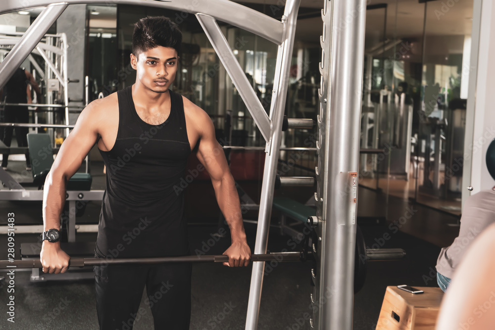 training shot of a young man in the gym, dumbbell, shrugs training shot of a young man in the gym, dumbbell, shrugs