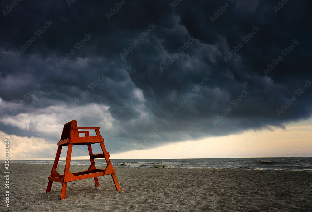 Fototapeta premium Orange lifeguard station under very stormy skies on the Atlantic Coast